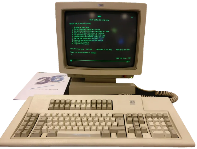 Een IBM System/36-terminal met groen scherm, toetsenbord en de handleiding ernaast
